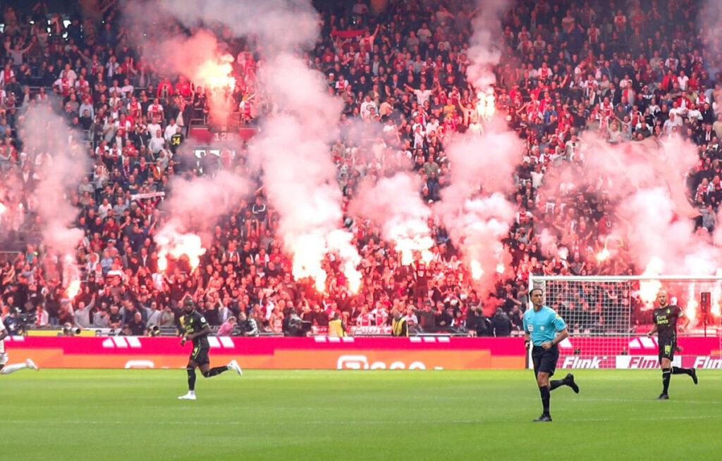 Fumogeni e fuochi d'artificio in campo durante Ajax-Feyenoord